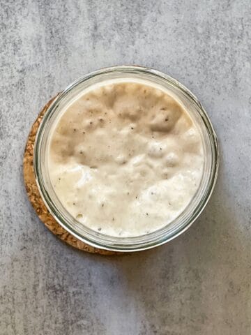Sourdough starter peak shown with overhead view on the jar with starter.