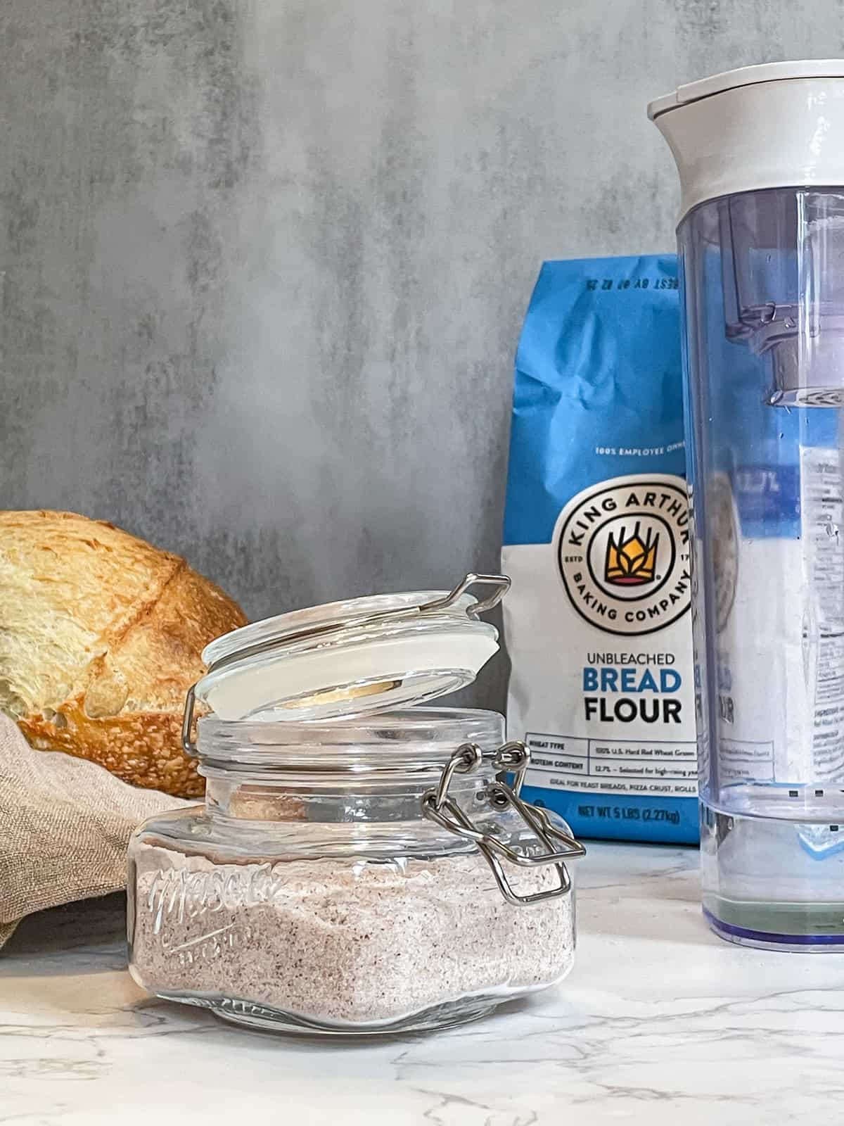 Sourdough bread ingredients (flour, water, and salt) alongside a loaf of bread.