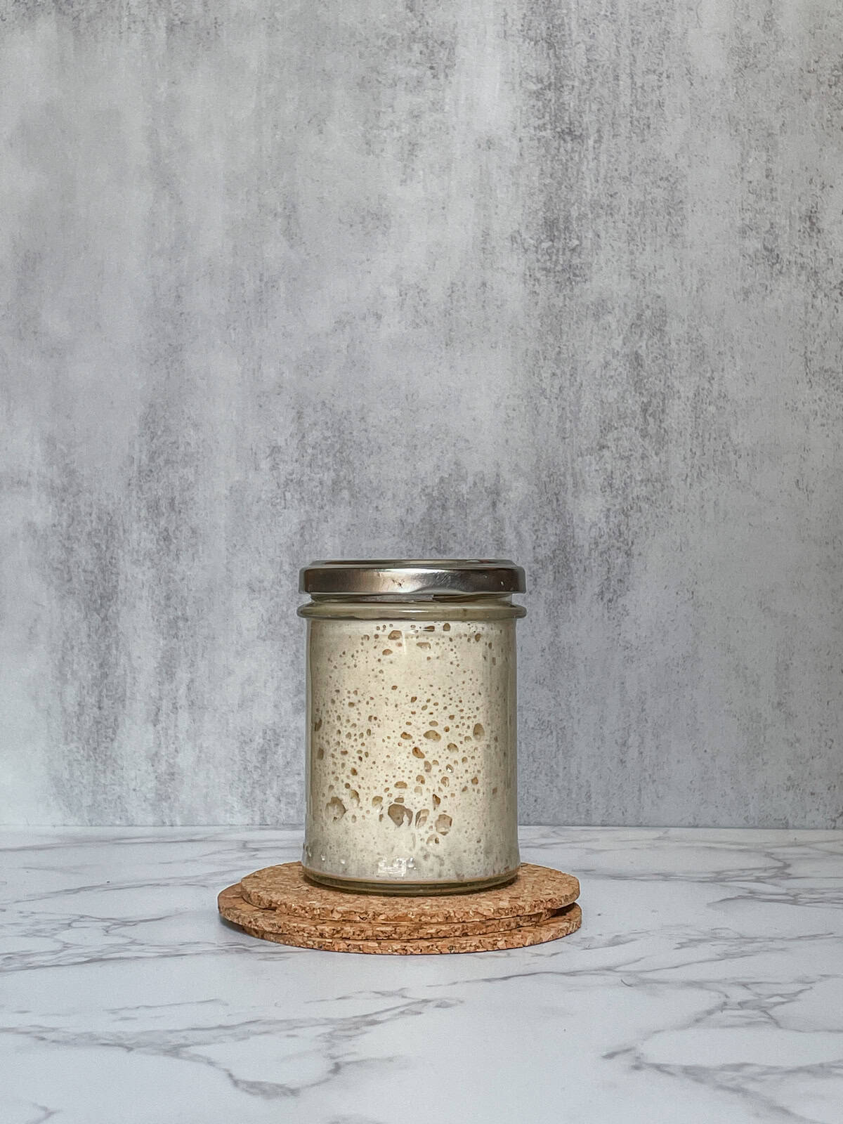 Active sourdough starter in a glass jar.