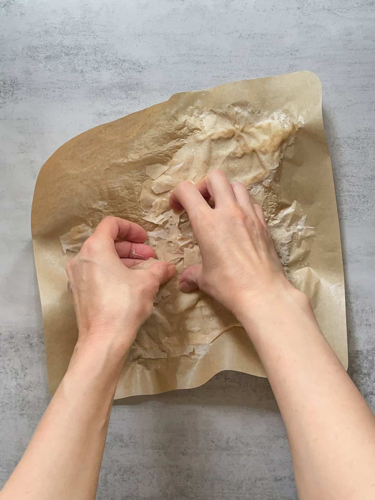 Breaking up dried sourdough starter with hands.