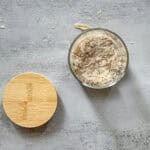 Dehydrated sourdough starter in a glass jar with a wooden lid nearby.