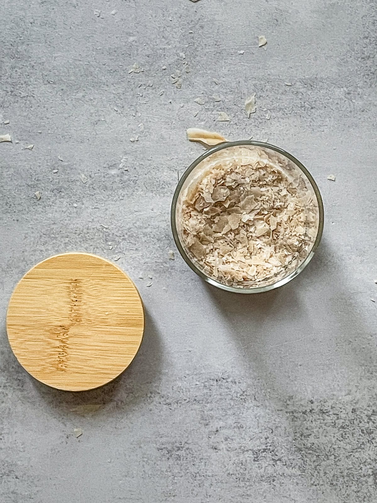 Dry sourdough starter in a glass jar with a wooden lid nearby.