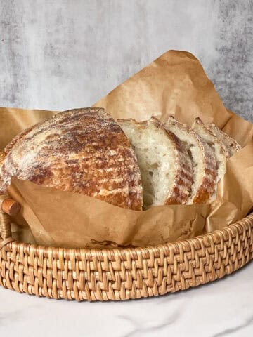Sliced Sliced low-hydration sourdough bread in a parchment-lined bread basket.