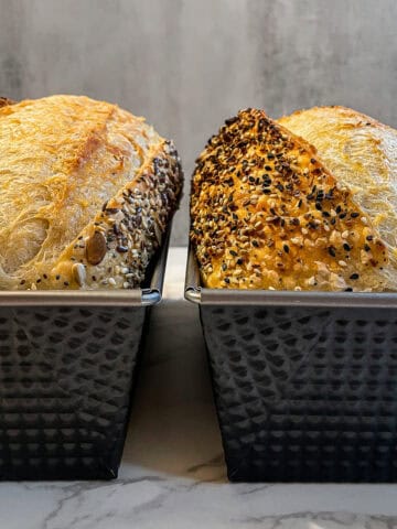 Two sourdough loaves in loaf pans, showing a batch baking method for multiple loaves.
