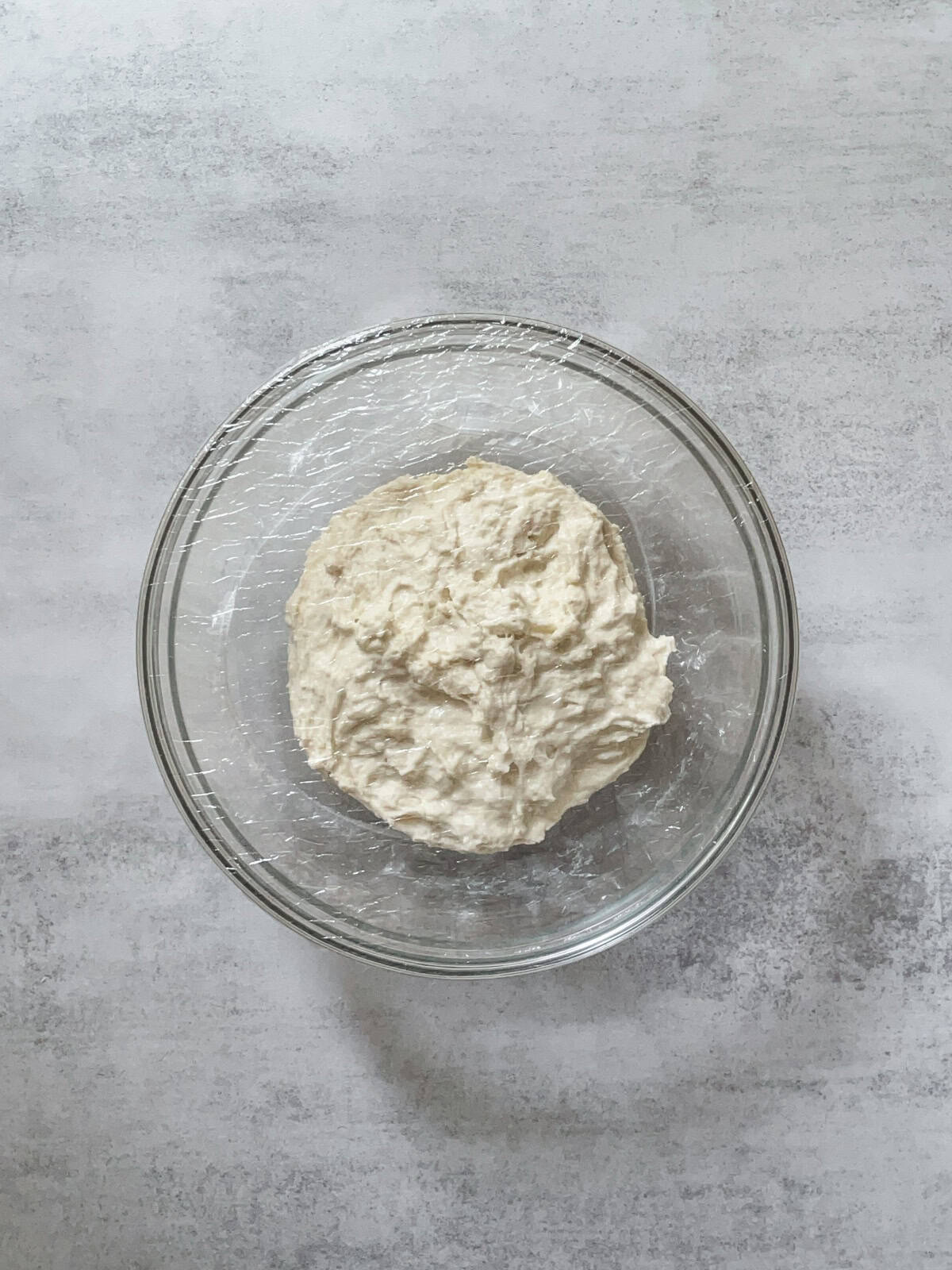 Sourdough dough in a glass bowl during the autolyse stage.