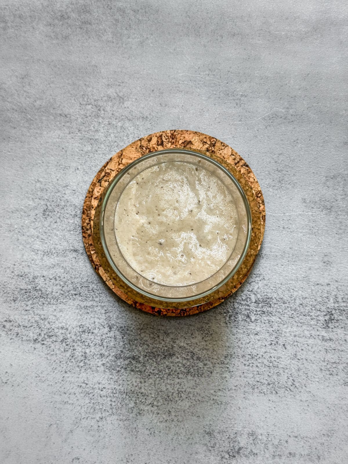 Overhead view of a sourdough starter nearly at its peak.