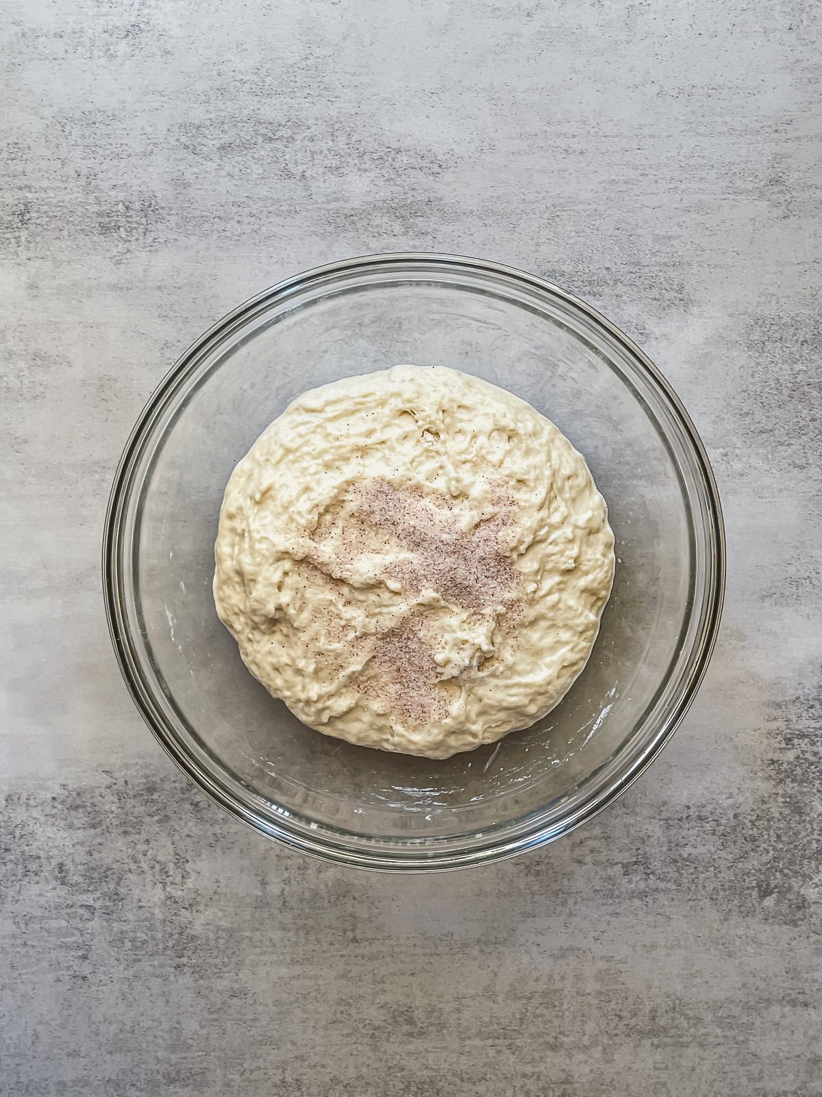 Dough mixture in a bowl with sea salt sprinkled on top.