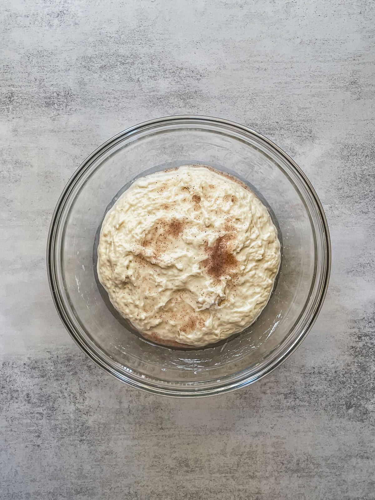 Bowl with dough mixture topped with salt and water.