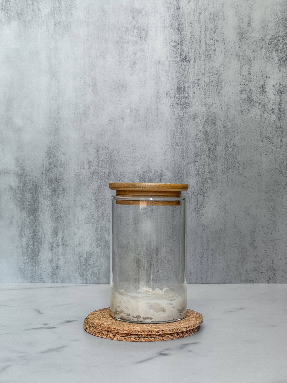 Jar of sourdough starter on day 1 morning after adding bread flour, front view.