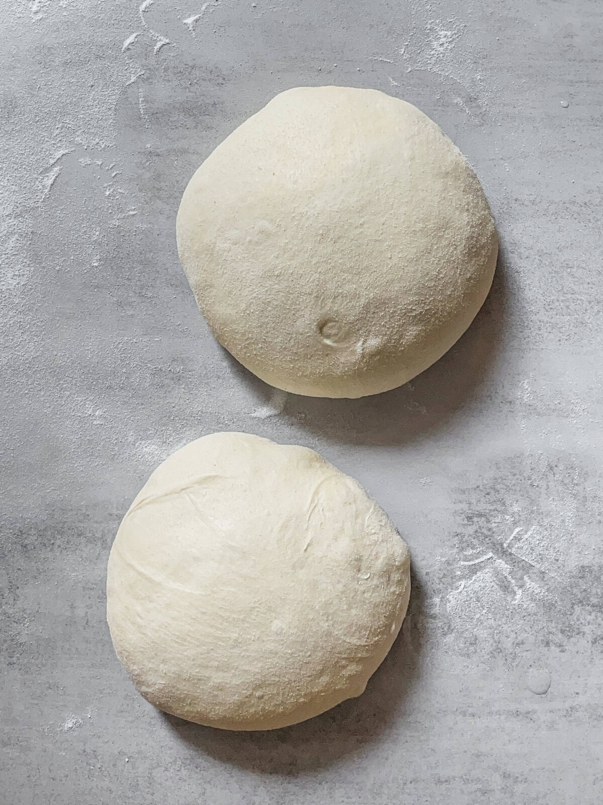 Preshaped balls of bread dough resting on a table.