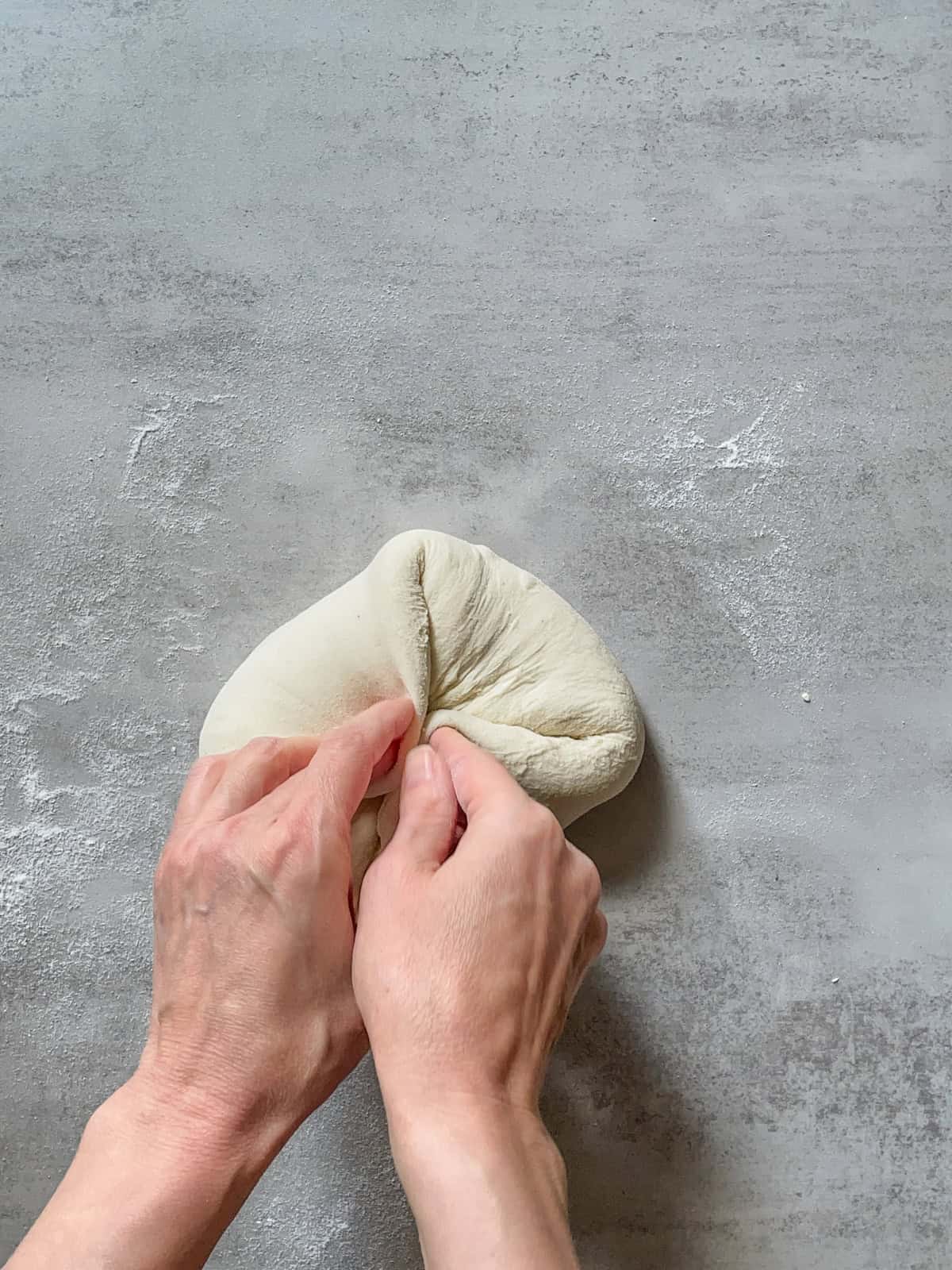Hands folding the dough at a 45-degree angle.