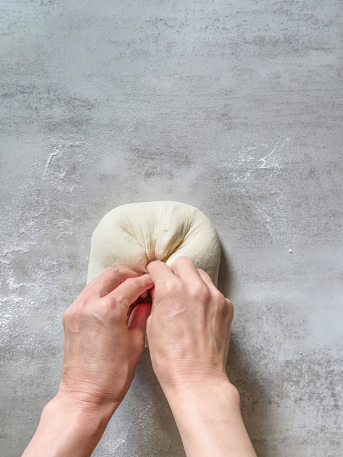 Hands folding the dough at the opposite 45-degree angle to complete the turn.