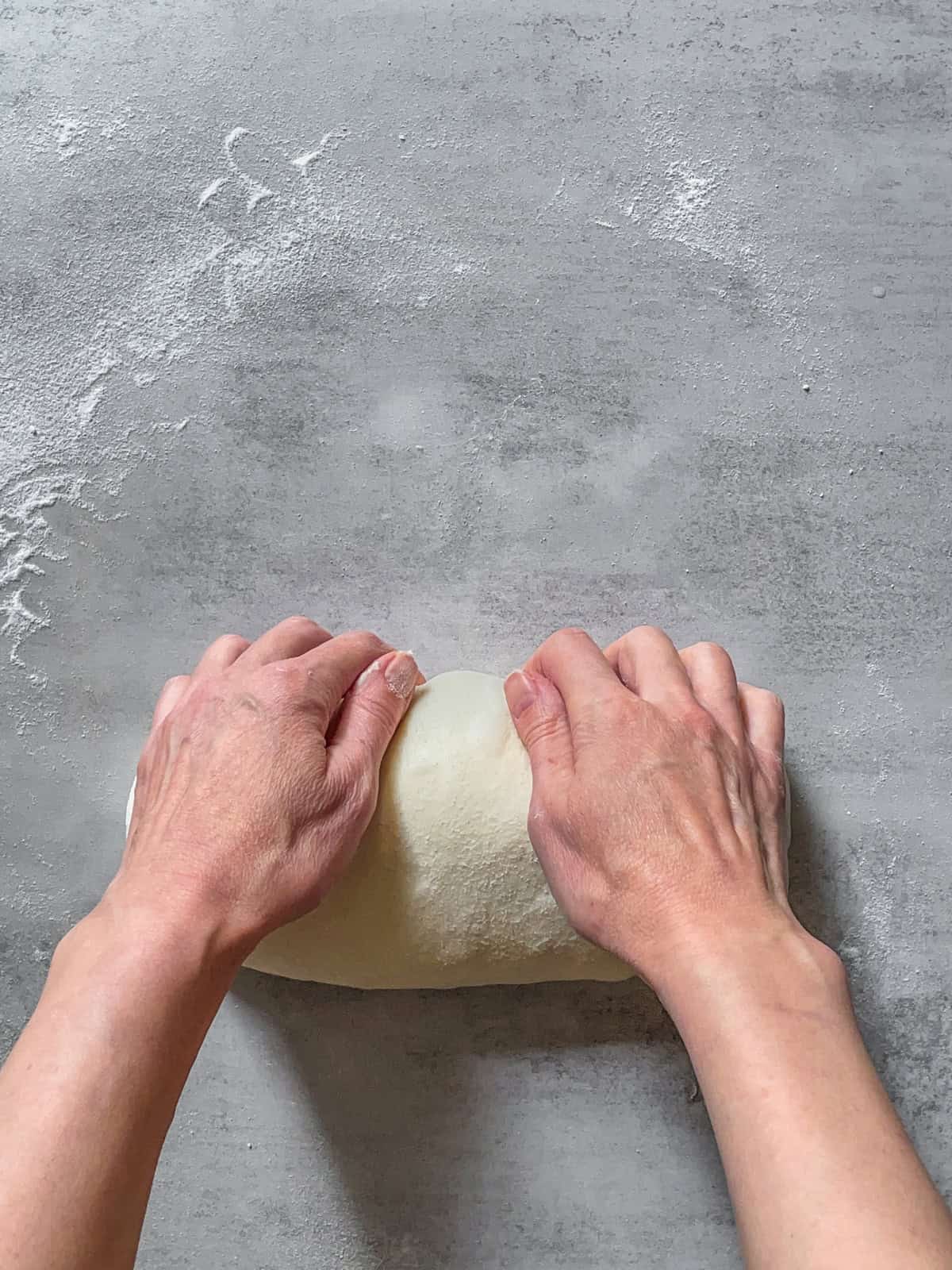 Hands tightening the batard seam by pulling it along the surface.