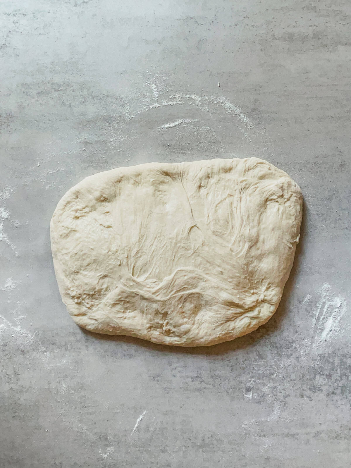 Bread dough resting sticky side up on a table.