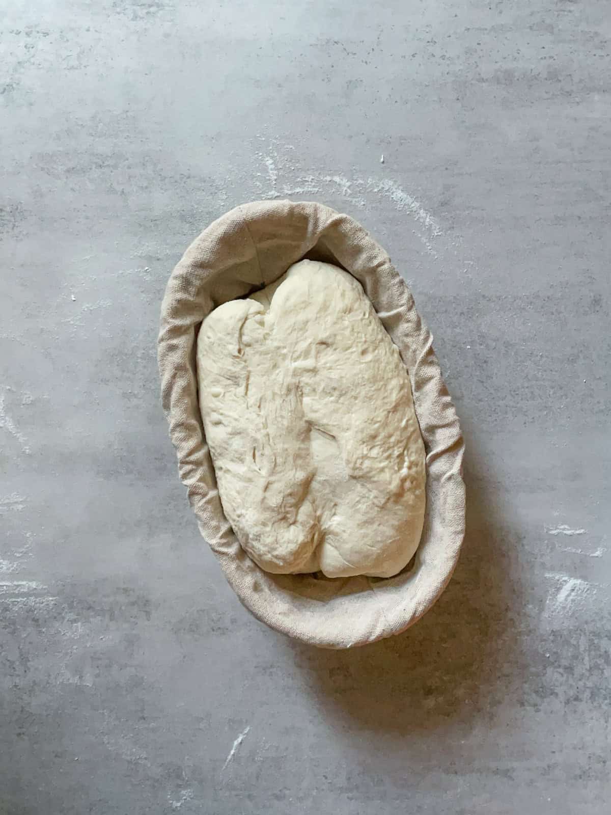 Shaped batard placed seam-side up in a lined banneton.