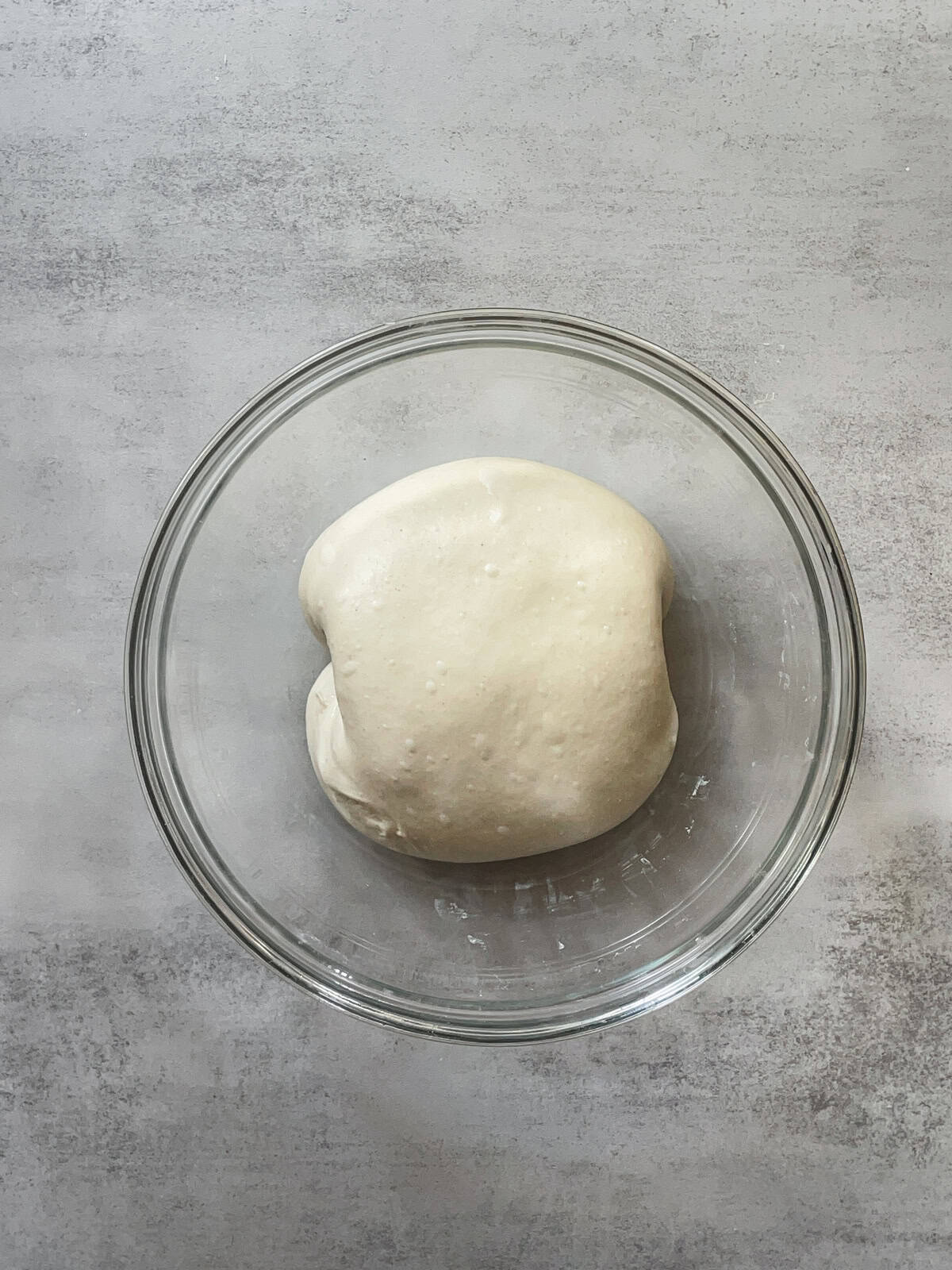 Folded bread dough in a mixing bowl.