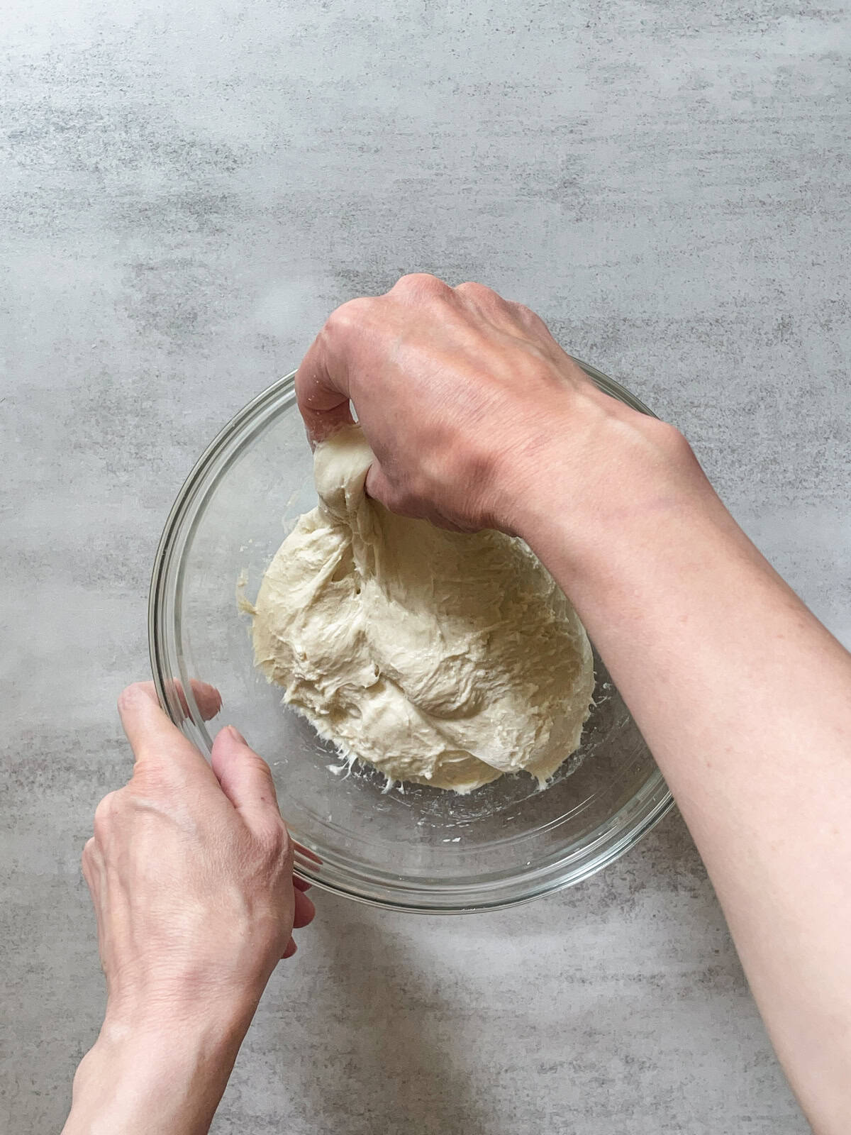 Hand lifting the dough during stretch and folds.