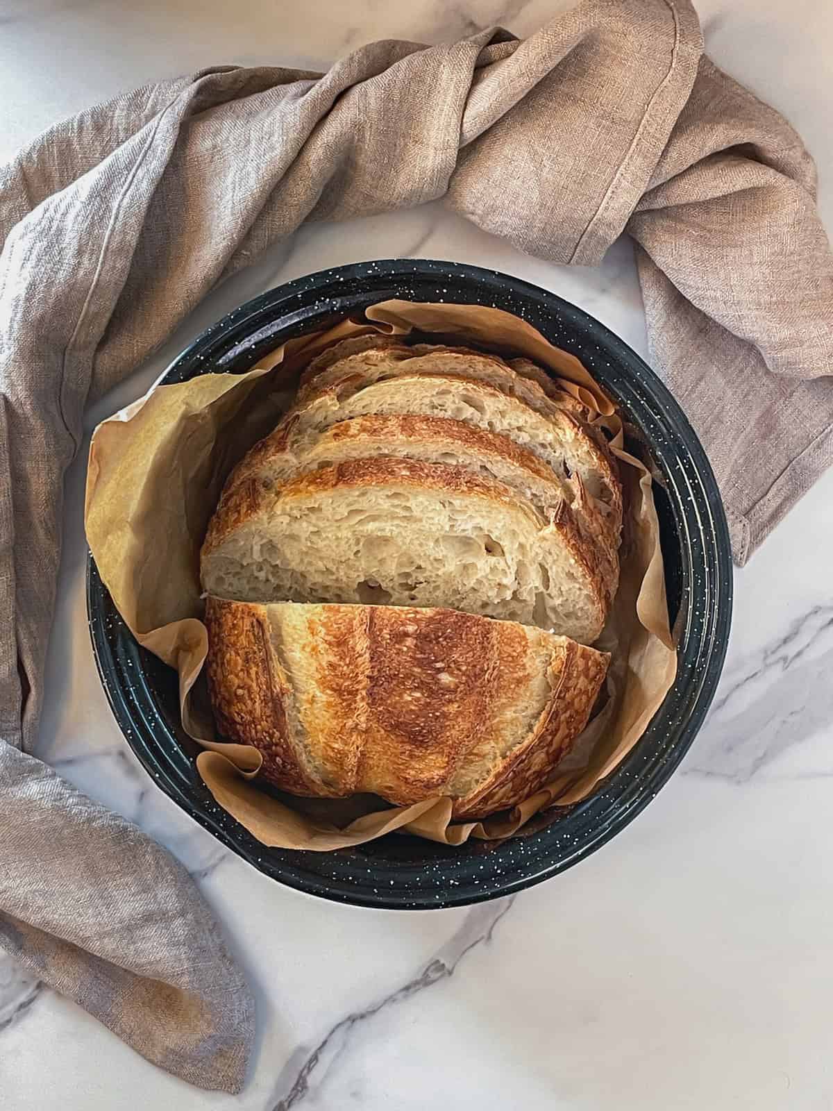 Sliced best homemade sourdough bread in a roasting pan.