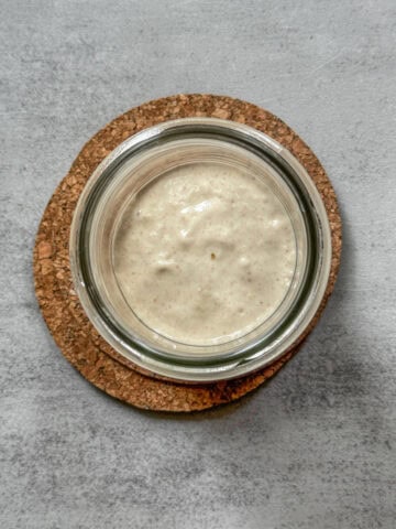 Sourdough starter in a jar after feeding, overhead view.