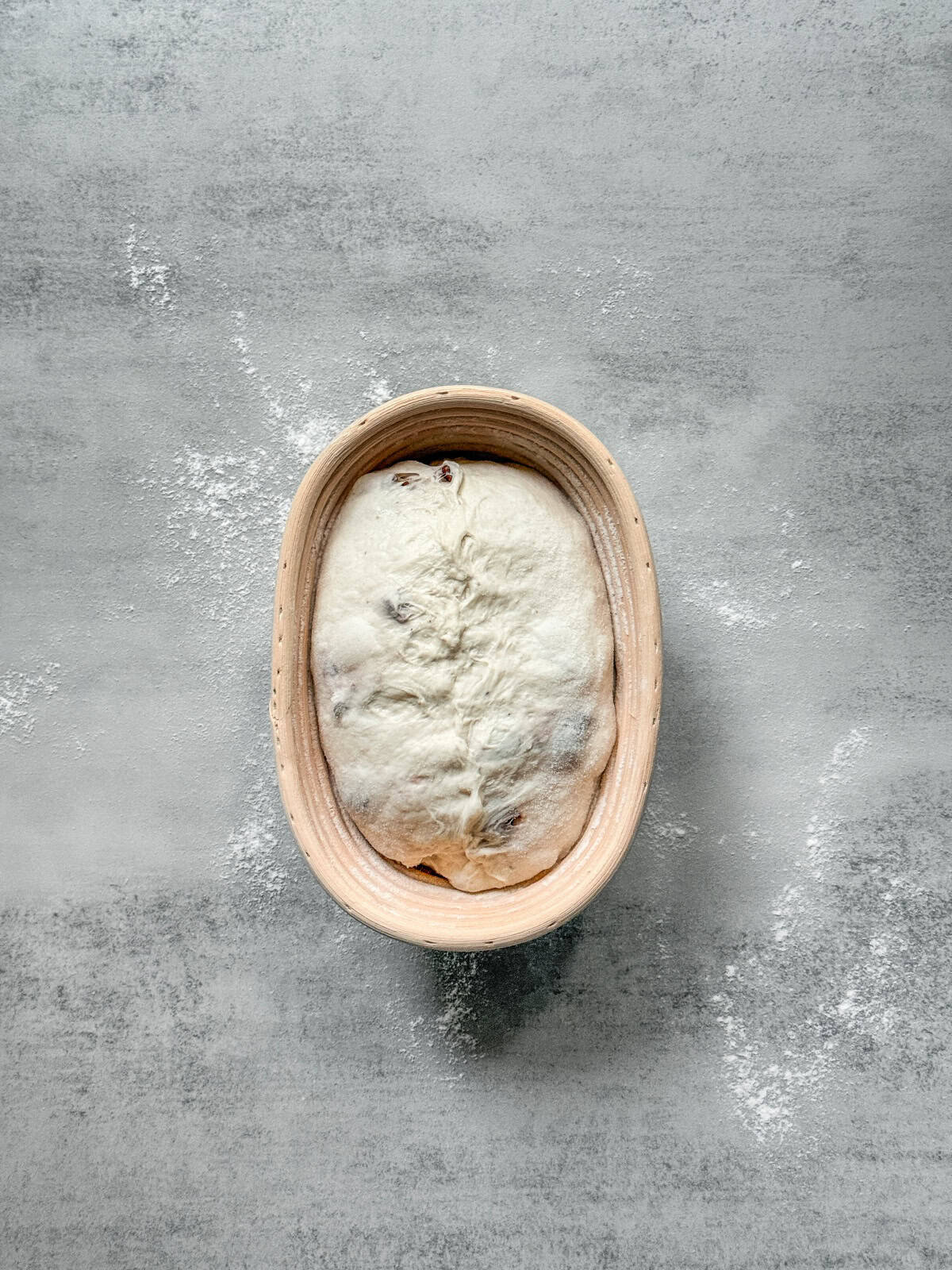 Shaped sourdough dough proofing in an oval banneton, filled to the right level without overflowing.