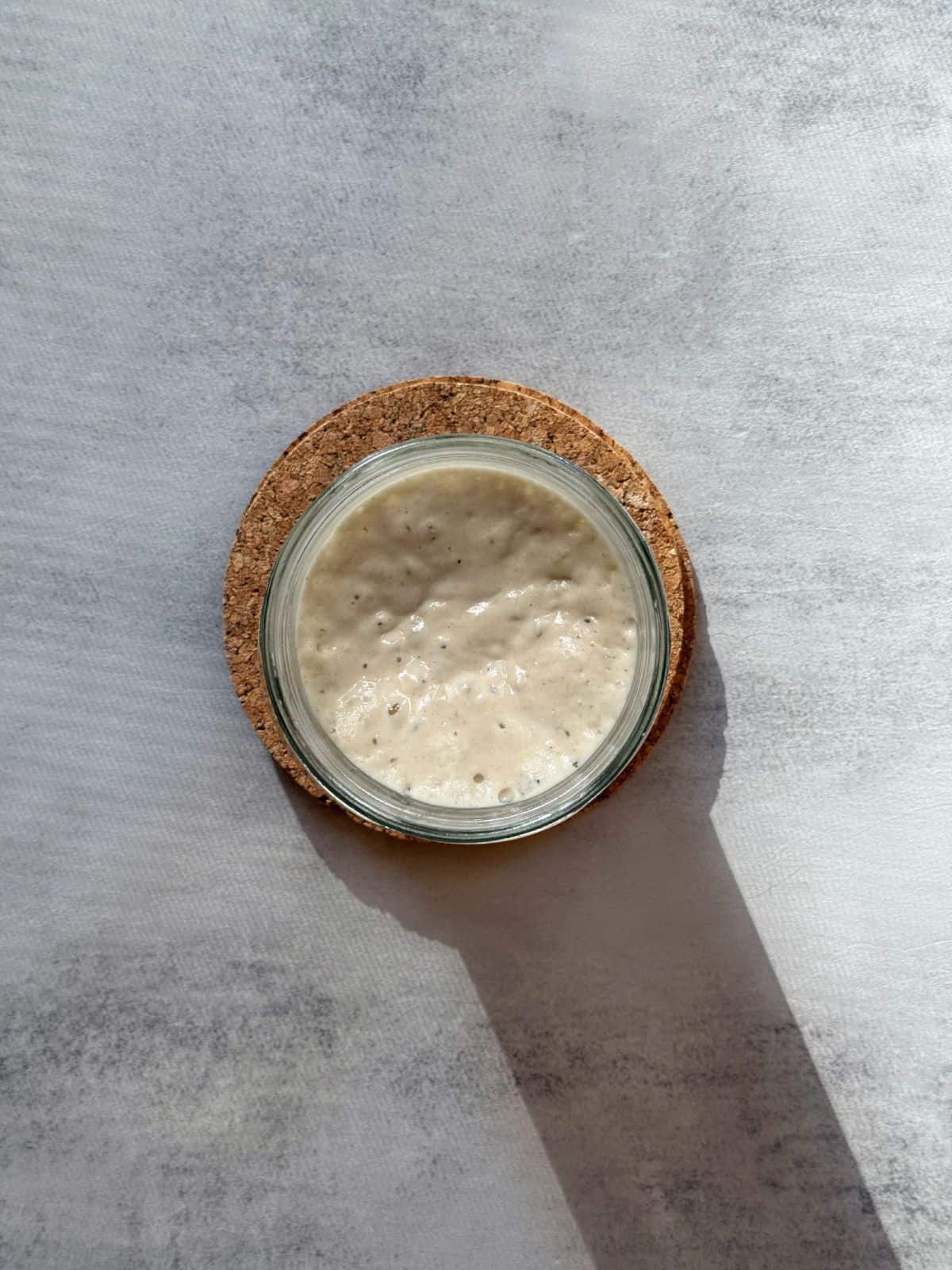 Sourdough starter in a jar in a summer day.