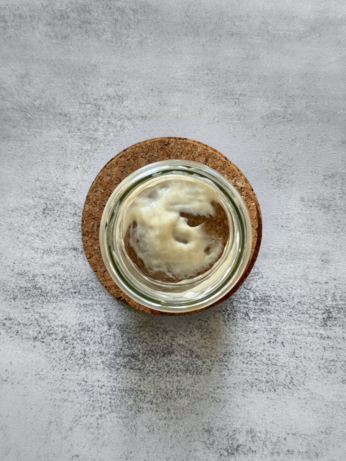 A jar with leftover sourdough starter clinging to the bottom and sides.