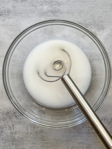 How much sourdough starter should you use: dissolving starter in water with a dough whisk