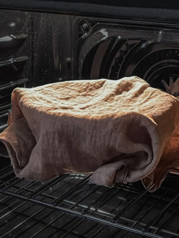 Bread dough proofing in an oven with the light on.