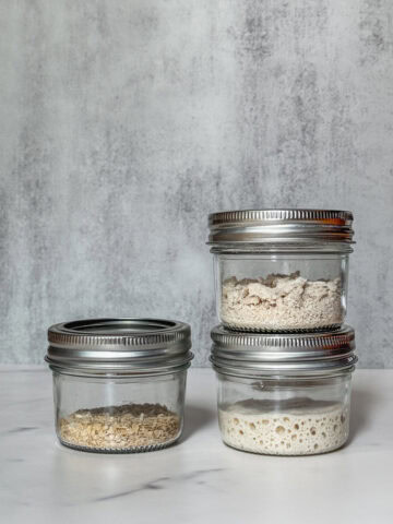 Three jars of sourdough starter stored using different methods.