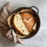 Unloafed sourdough bread sliced in half in a Dutch oven.