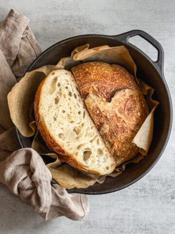 Unloafed sourdough bread sliced in half in a Dutch oven.