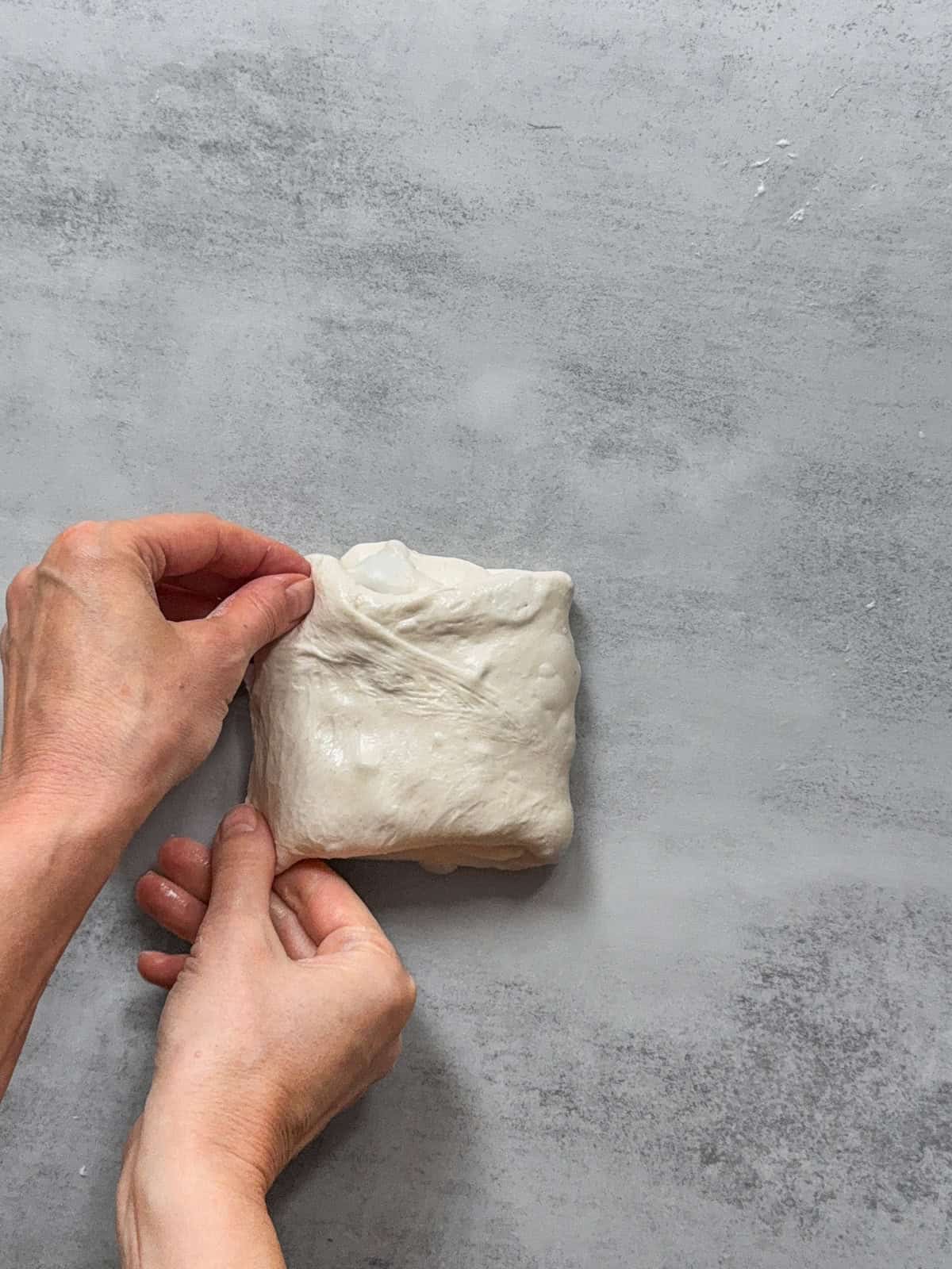 Hands completing the fold.