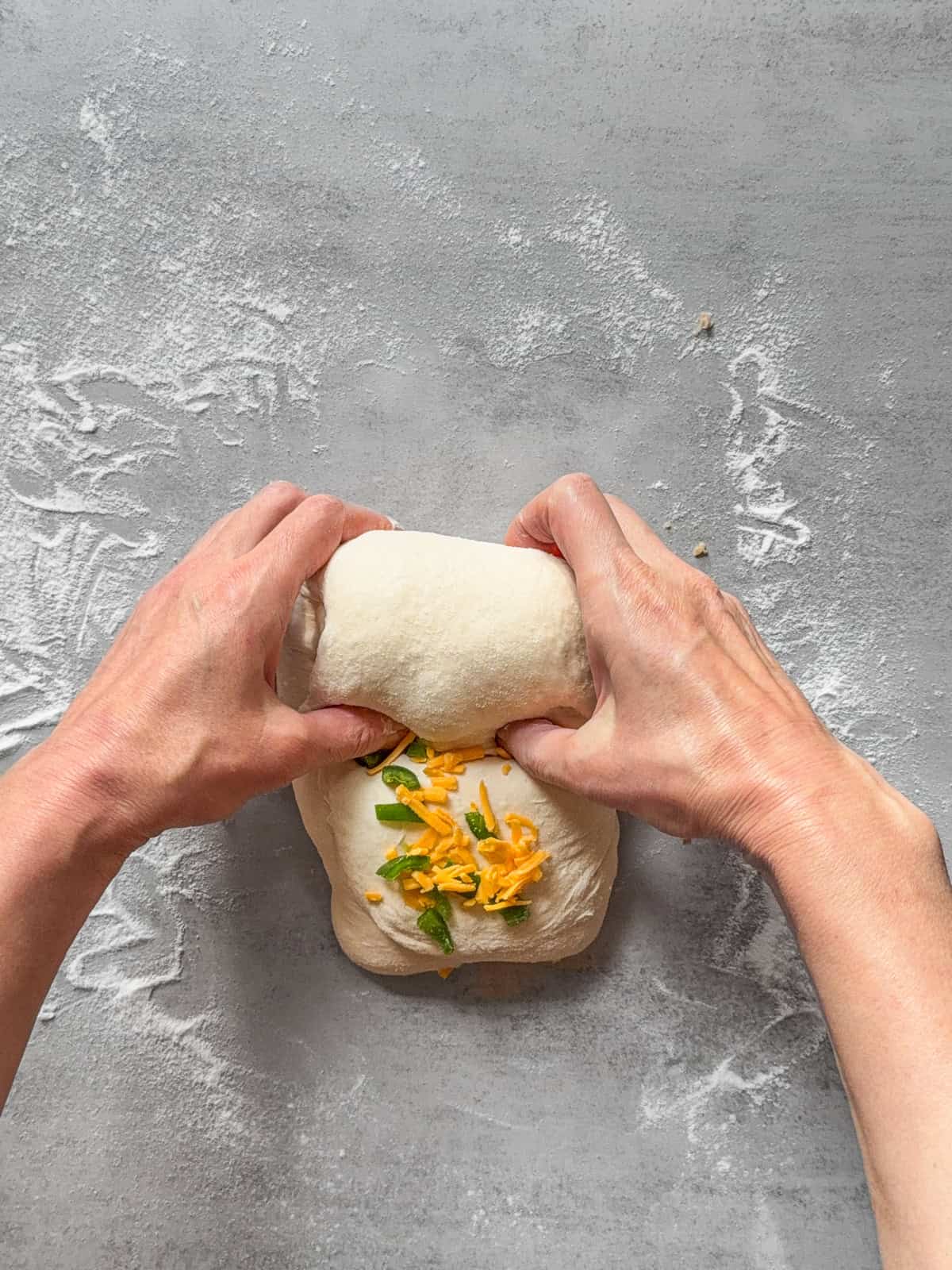 Hands midway through rolling the dough.