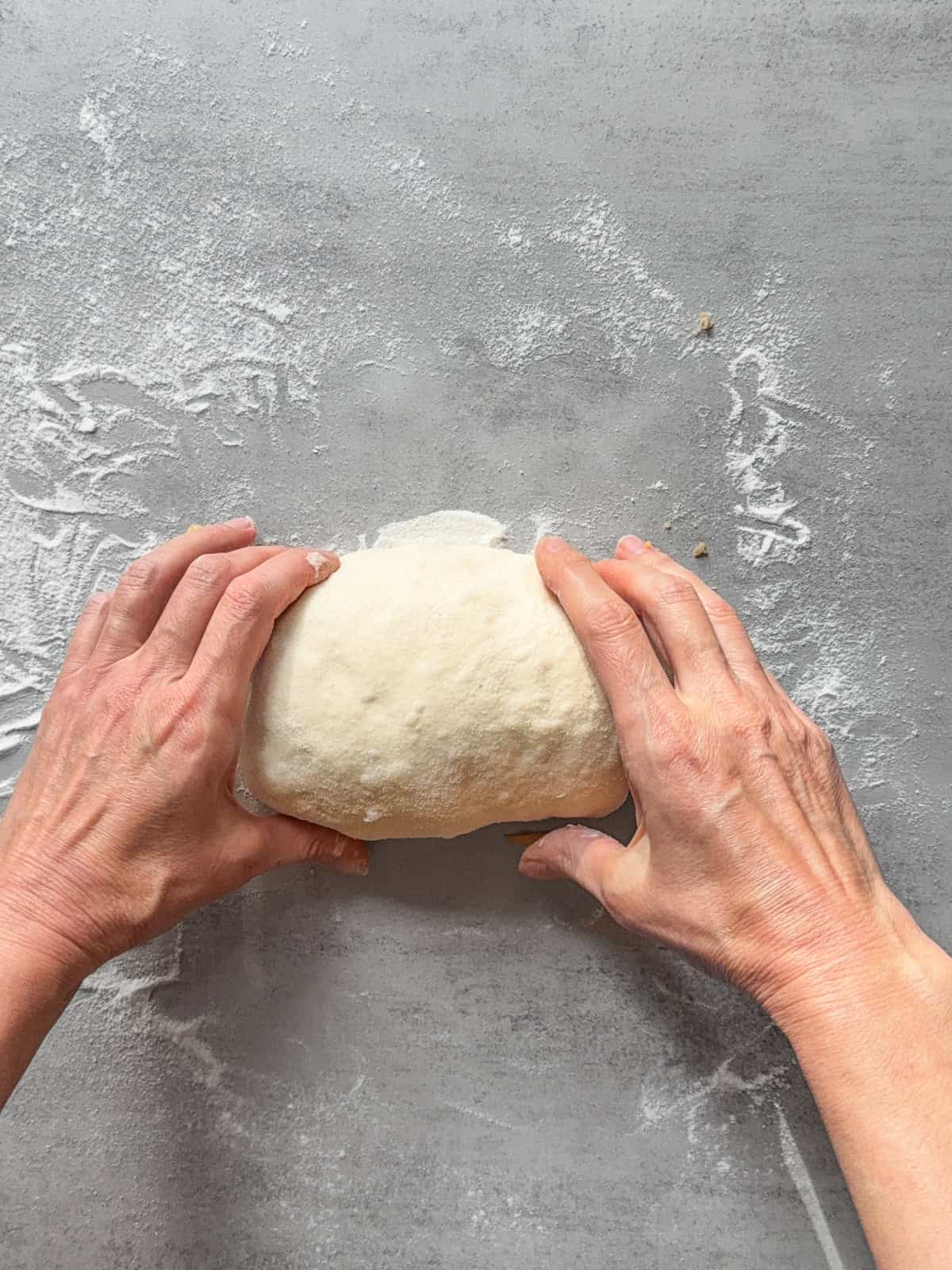 Hands finishing the roll, shaping the dough tightly.