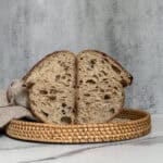 Halved artisan sourdough bread in a rattan tray.