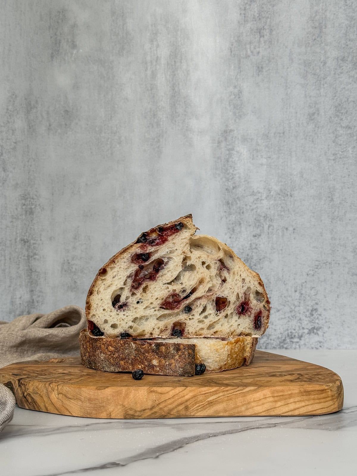 Half of Taylor Swift’s lemon blueberry sourdough bread on a wooden board.