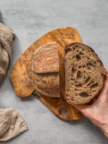 Halved Guinness sourdough bread held in hand.
