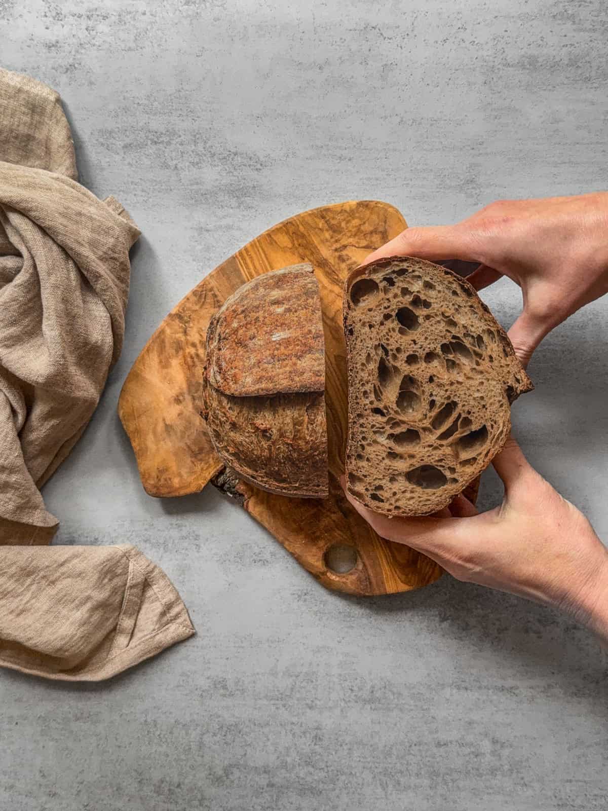 Halved Guinness sourdough bread held in hands.