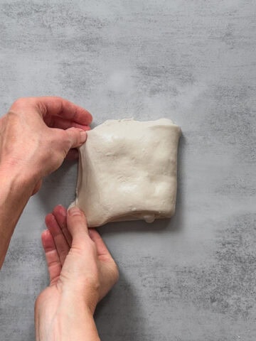Hands holding laminated sourdough.