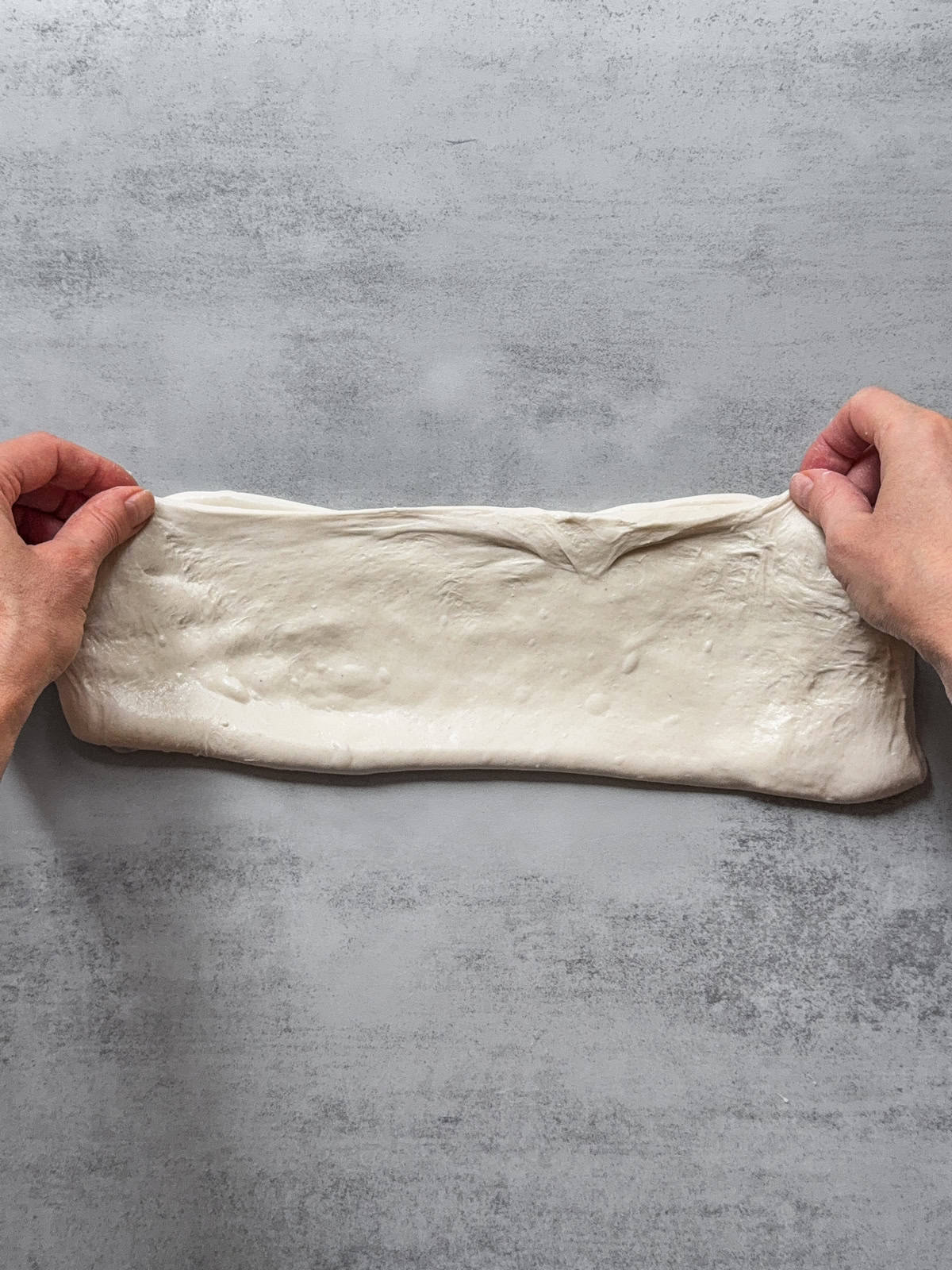 Hands folding the bottom third over the upper third.