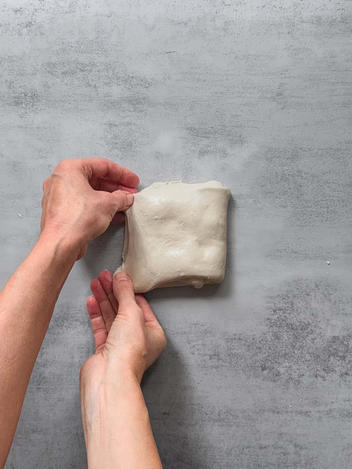 Hands folding the right third to complete the fold.