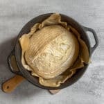 Parbaked sourdough bread loaf in a Dutch oven.