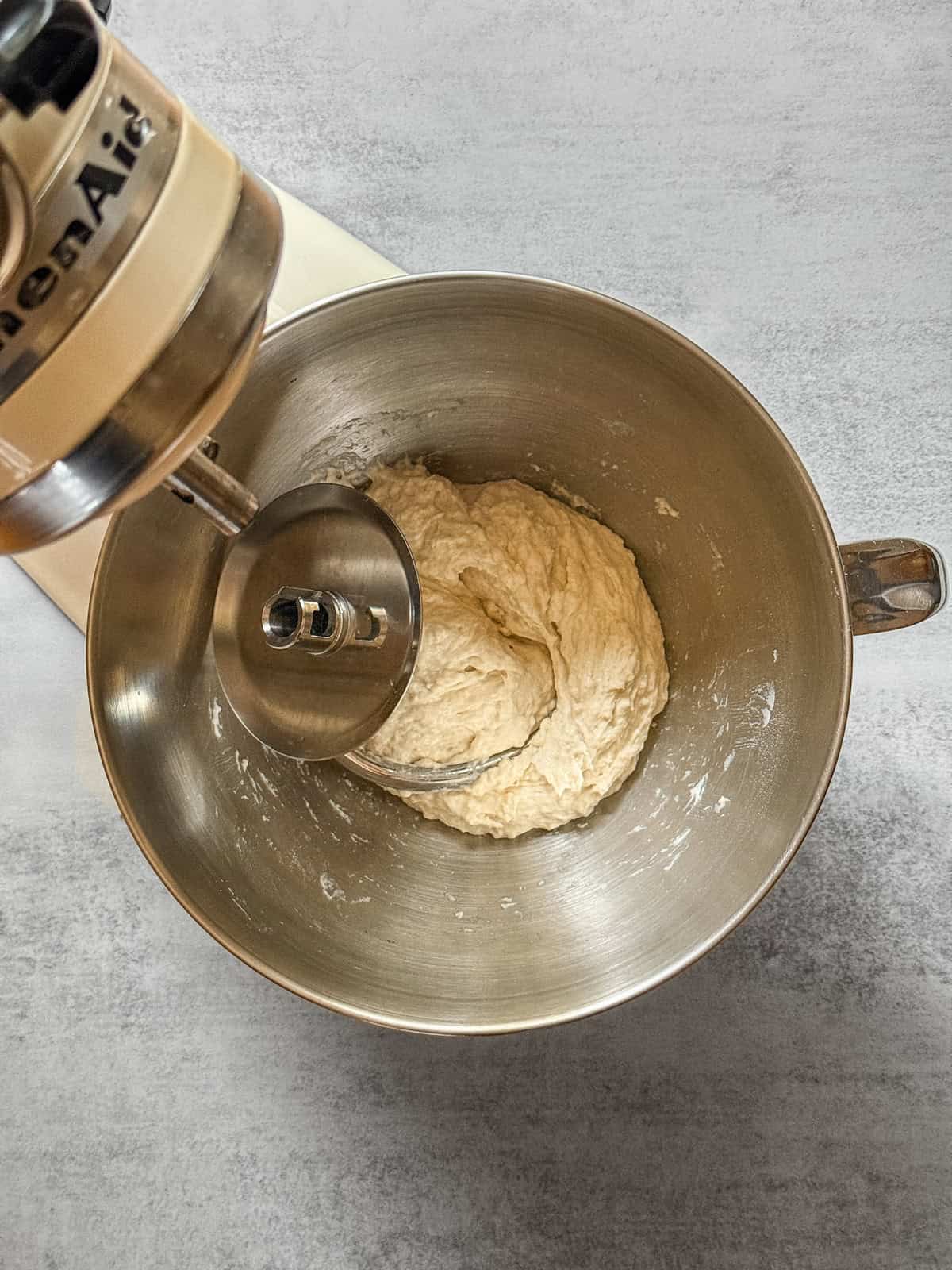 Sourdough dough in a stand mixer bowl during autolyse.