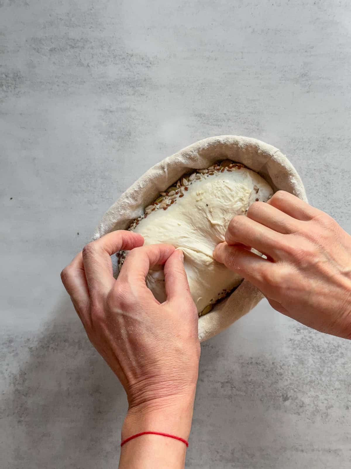 Hans stitching the dough in a banneton.