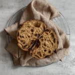 Halved black garlic sourdough bread loaf on a kitchen towel.