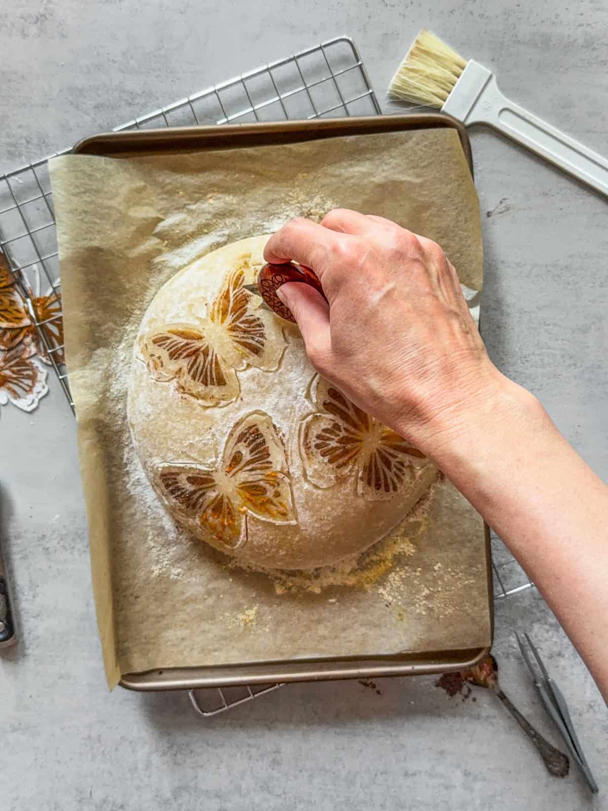 Hand making cuts along the design using the UFO bread lame.