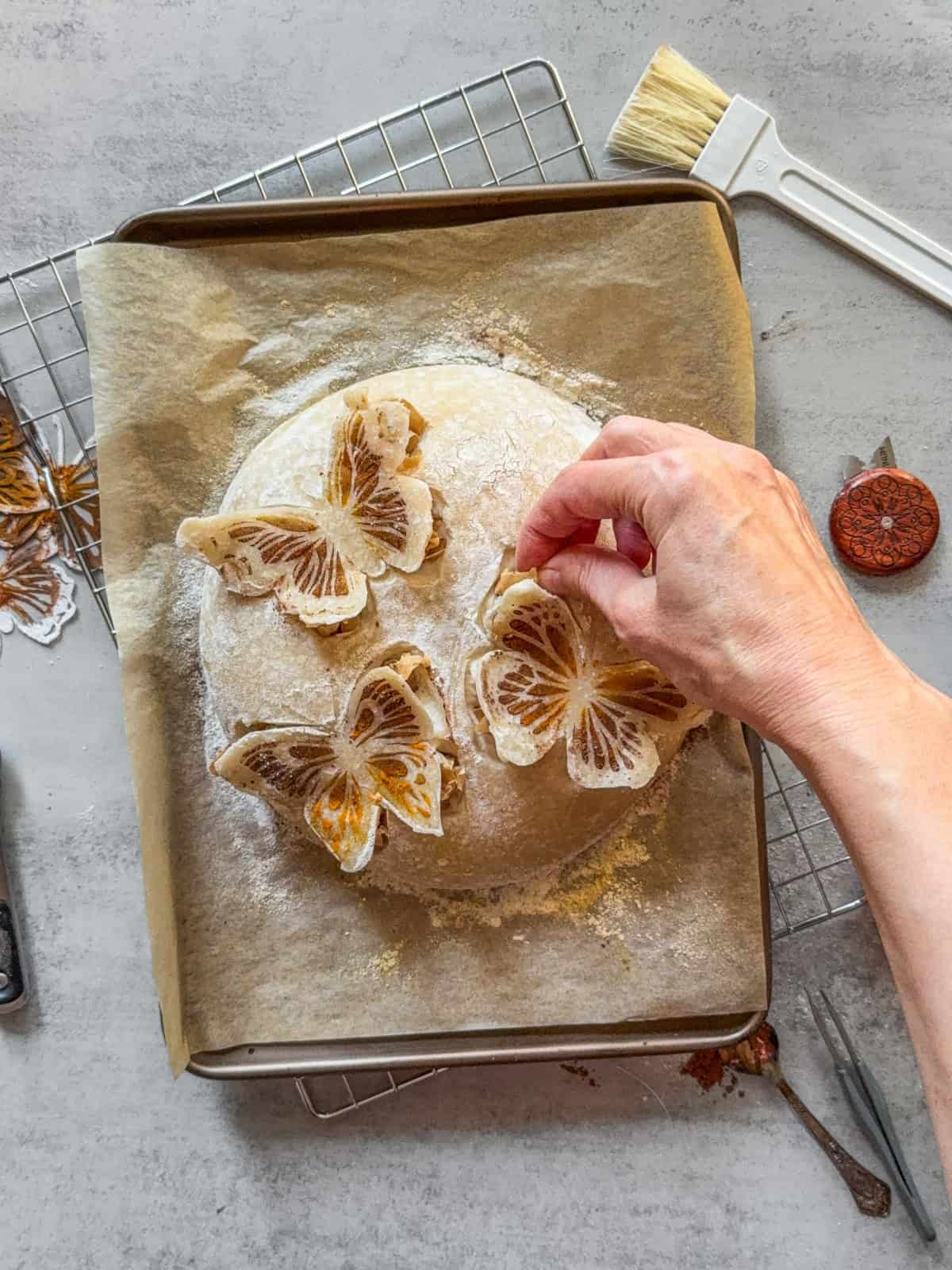 Hand placing a parchment paper ball under the butterfly wing for a 3D effect.