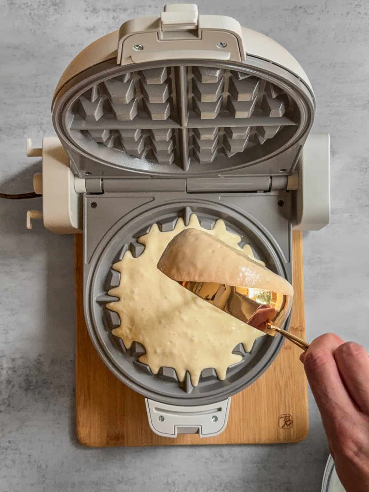 Batter being poured into a waffle iron.