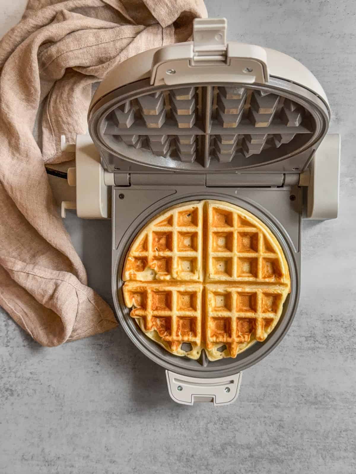 Cooked waffle in a waffle iron.